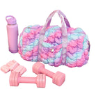 Colorful tie-dye duffel bag with pink dumbbells and water bottle on a purple surface