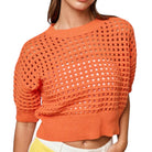 Orange open-knit sweater worn by a person on a white background