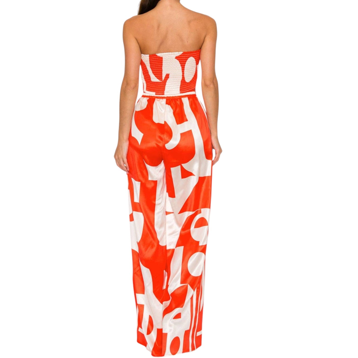 Woman wearing a strapless set with orange and white abstract pattern on a white background