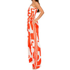 Woman wearing a strapless orange and white patterned set on a white background