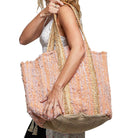 Woman holding a colorful woven bag on a white background