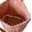 Close-up of a textured brown leather bag with a strap.