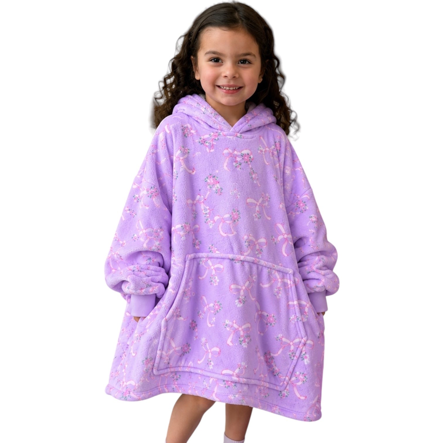 A young girl with curly brown hair wearing a lavender purple hooded sweatshirt blanket with a pink bow pattern, standing against a solid white background.