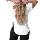 Person wearing a white t-shirt and black leggings with long blonde hair.