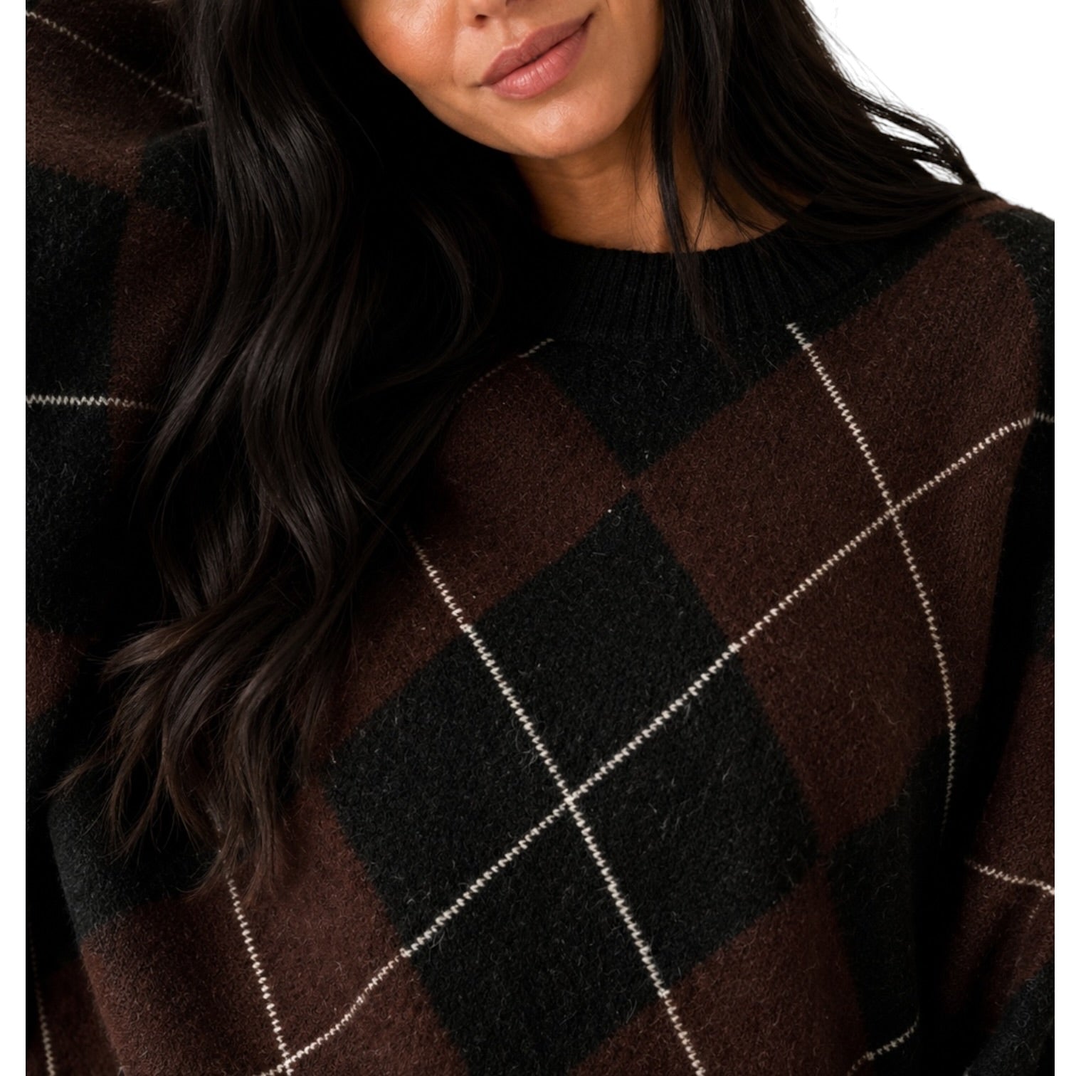 Close-up of a woman wearing a dark brown and black argyle sweater with thin white diagonal stripes, against a plain white background.