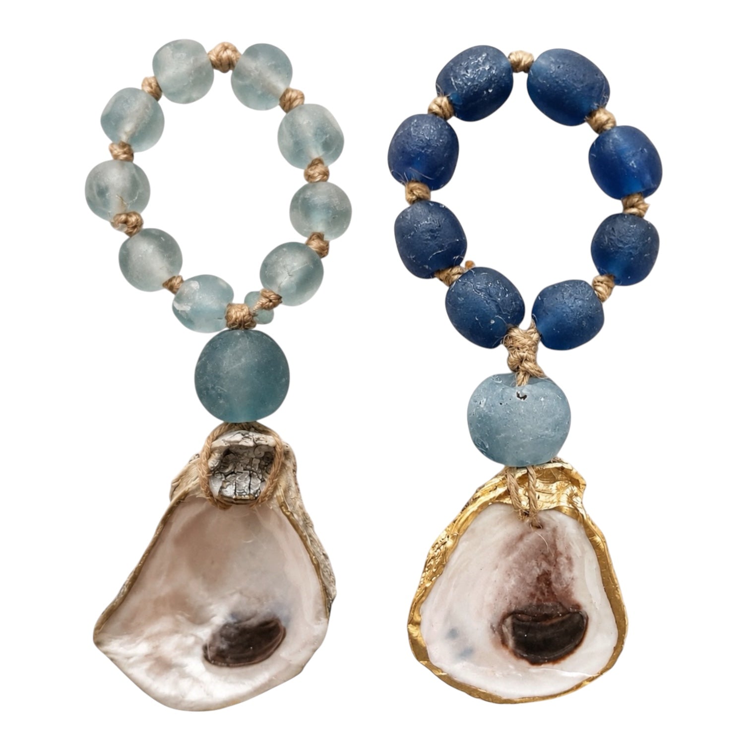 Two beaded drop earrings on a white background. One earring features light blue beads, a larger light blue bead, and a natural oyster shell pendant with gold trim.