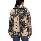 A woman viewed from the back wearing a sherpa fleece jacket with a black and cream paisley patchwork pattern, paired with blue jeans against a plain white background.