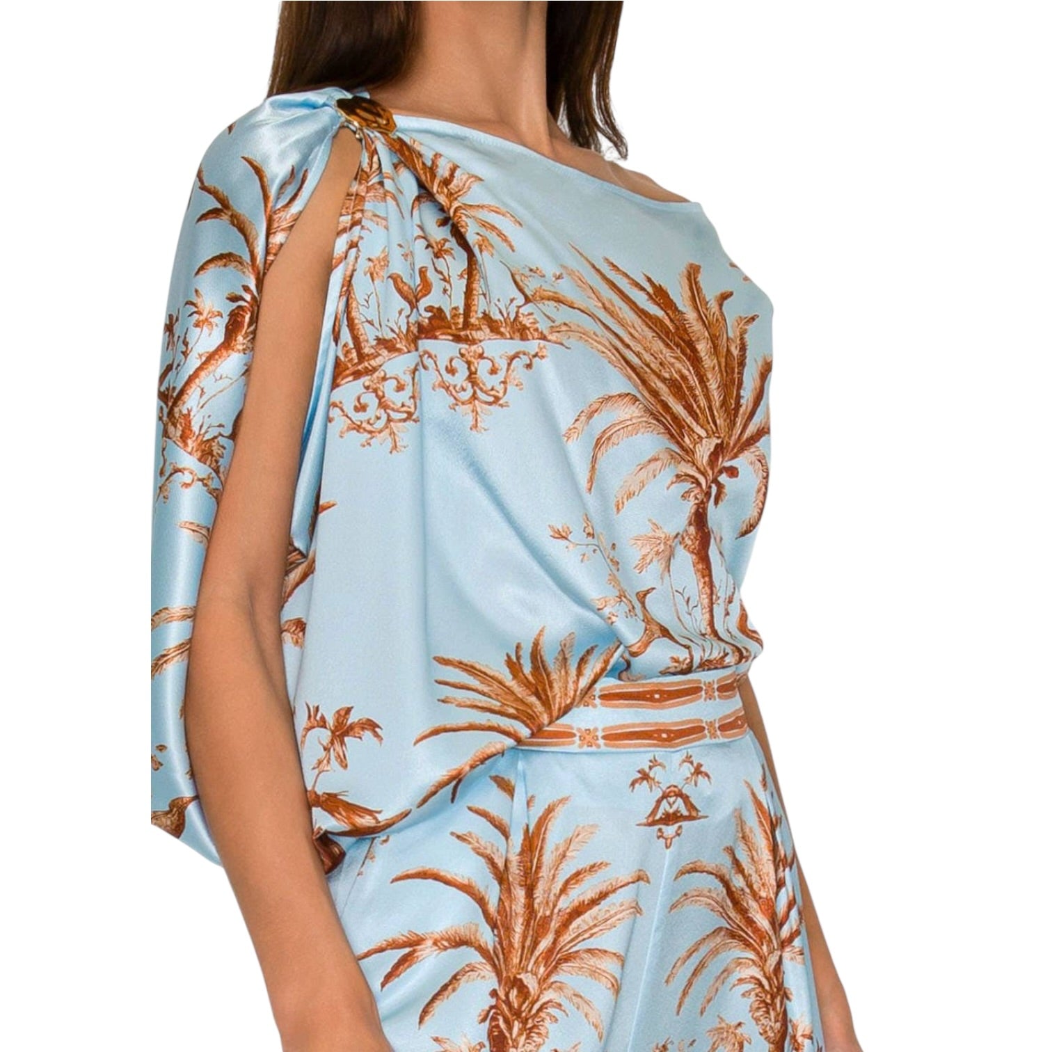 Light blue fabric with brown floral pattern draped over a person on a white background