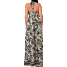 Woman wearing a black and white floral halter neck dress on a white background