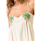 White dress with green palm tree designs on a white background