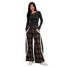 A woman modeling a dark charcoal long-sleeve top and wide-leg plaid pants with white side panels, standing against a plain white background.