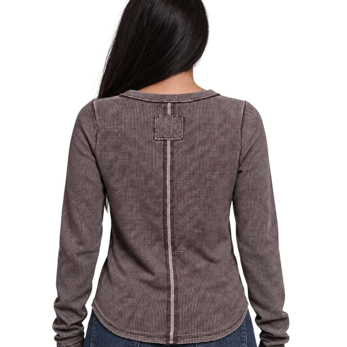 A woman viewed from the back wearing a long-sleeve waffle-knit top in a dark taupe-brown color, featuring a central seam and a square patch detail on the upper back.
