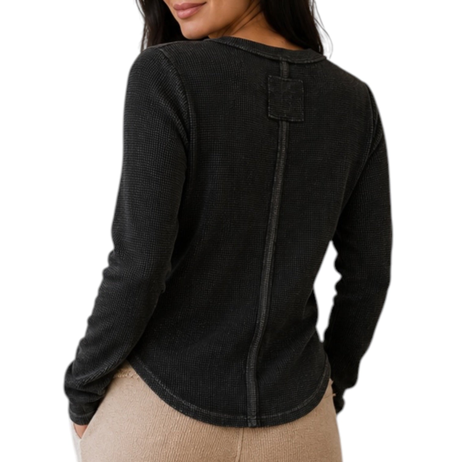 A woman wearing a black waffle-knit long-sleeve top, shown from the back against a plain white background.