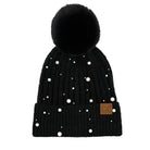 A black ribbed knit pom-pom beanie decorated with scattered white faux pearls and featuring a small brown leather 'CG' brand patch on the cuff, shown against a plain white background.