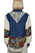 Person wearing a patchwork vest with a floral pattern on a plain background