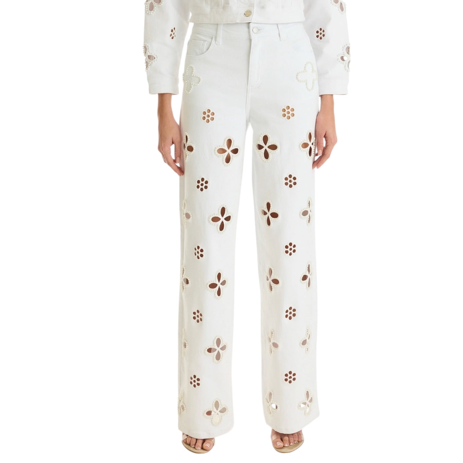 White pants with brown floral patterns worn by a person on a white background