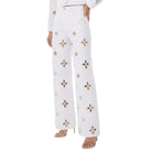 White pants with floral patterns worn by a person on a white background