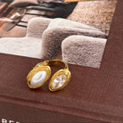 Gold earrings on a book