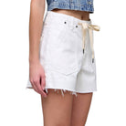 White denim skirt with a tie detail worn by a person on a white background