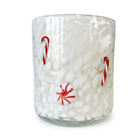 A clear glass tumbler candle with a white wax fill, decorated with red and white candy cane motifs and a small red-and-white swirl ornament, shown on a white background.
