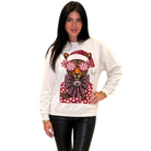 A woman modeling a white crewneck sweatshirt featuring a graphic of a leopard wearing a Santa hat and red polka-dot bow tie, paired with black faux-leather pants against a plain white background.