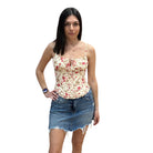 Woman wearing a floral top and denim skirt on a white background