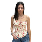 Woman wearing a floral top and jeans on a white background