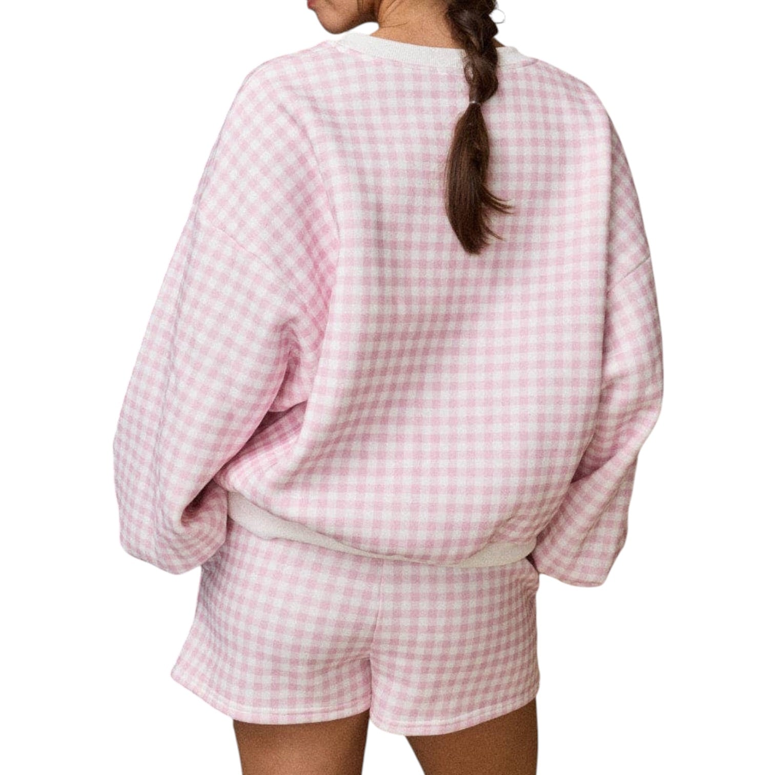 Person wearing a pink and white checkered outfit on a white background