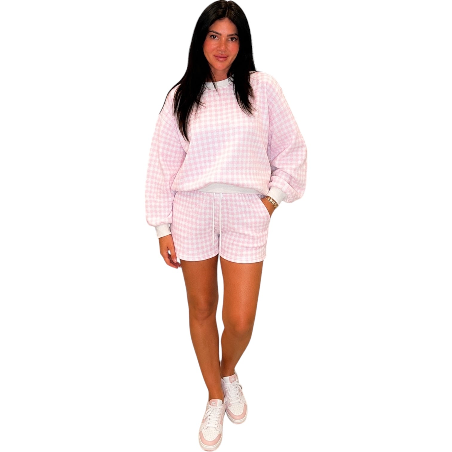 a woman wearing a pink gingham set on white background