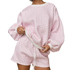 a woman wearing a pink gingham set on white background