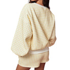 Yellow and white checkered outfit on a plain background
