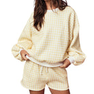 Person wearing a yellow checkered outfit on a white background