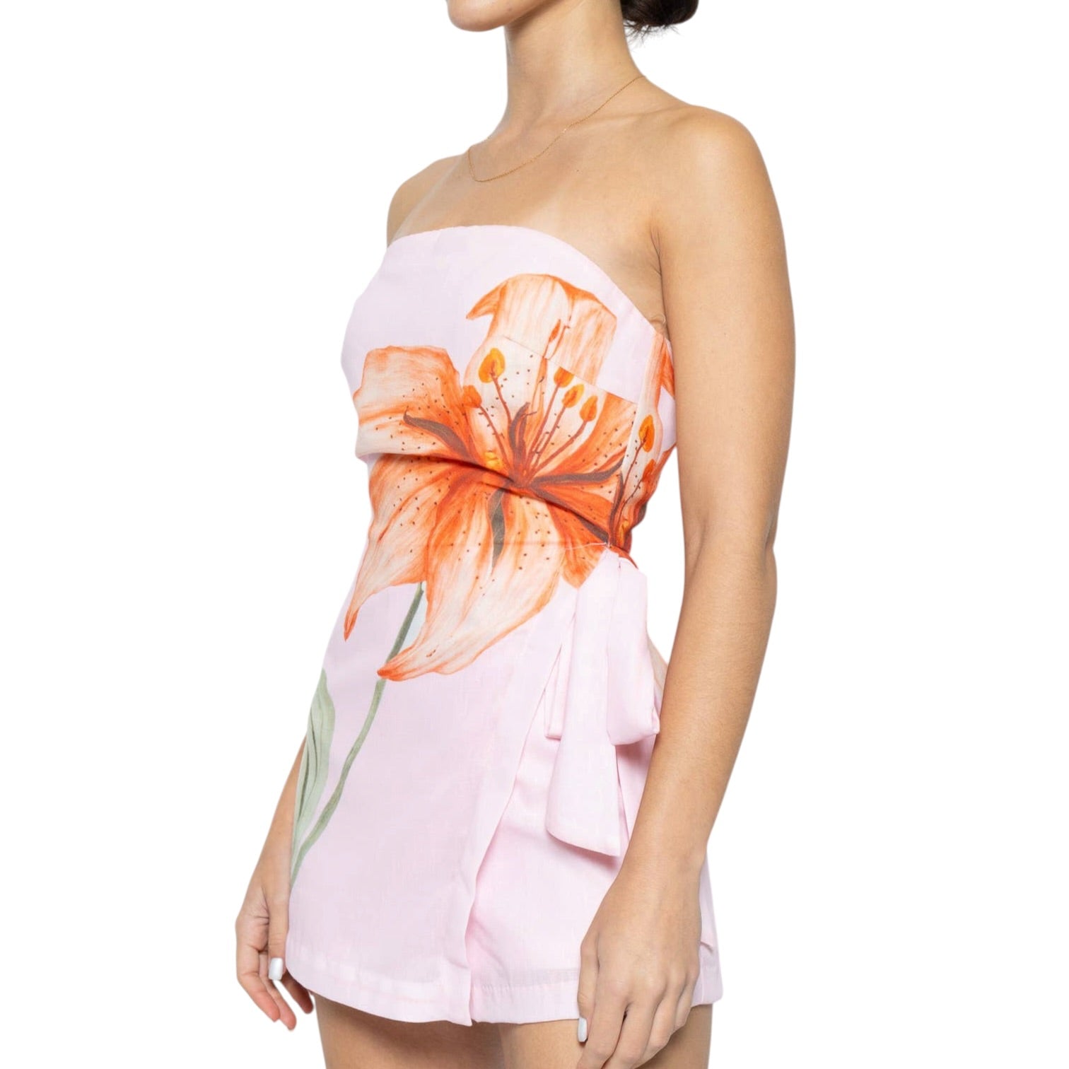 Woman wearing a strapless romper with floral design on a white background
