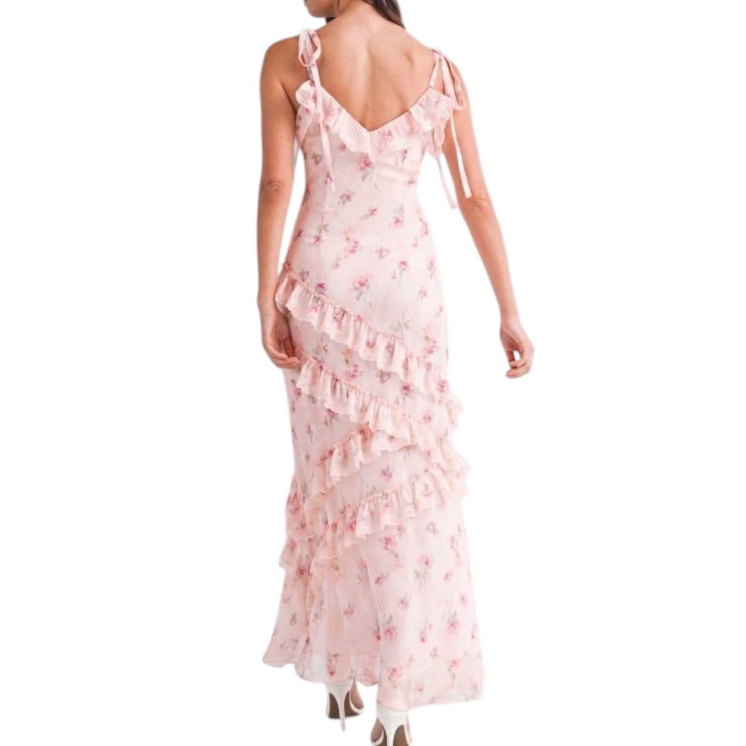 a woman wearing a pink floral dress with ruffles on white background