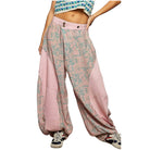 Person wearing pink patterned pants on a white background