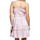 Pink tiered dress with thin straps on a white background