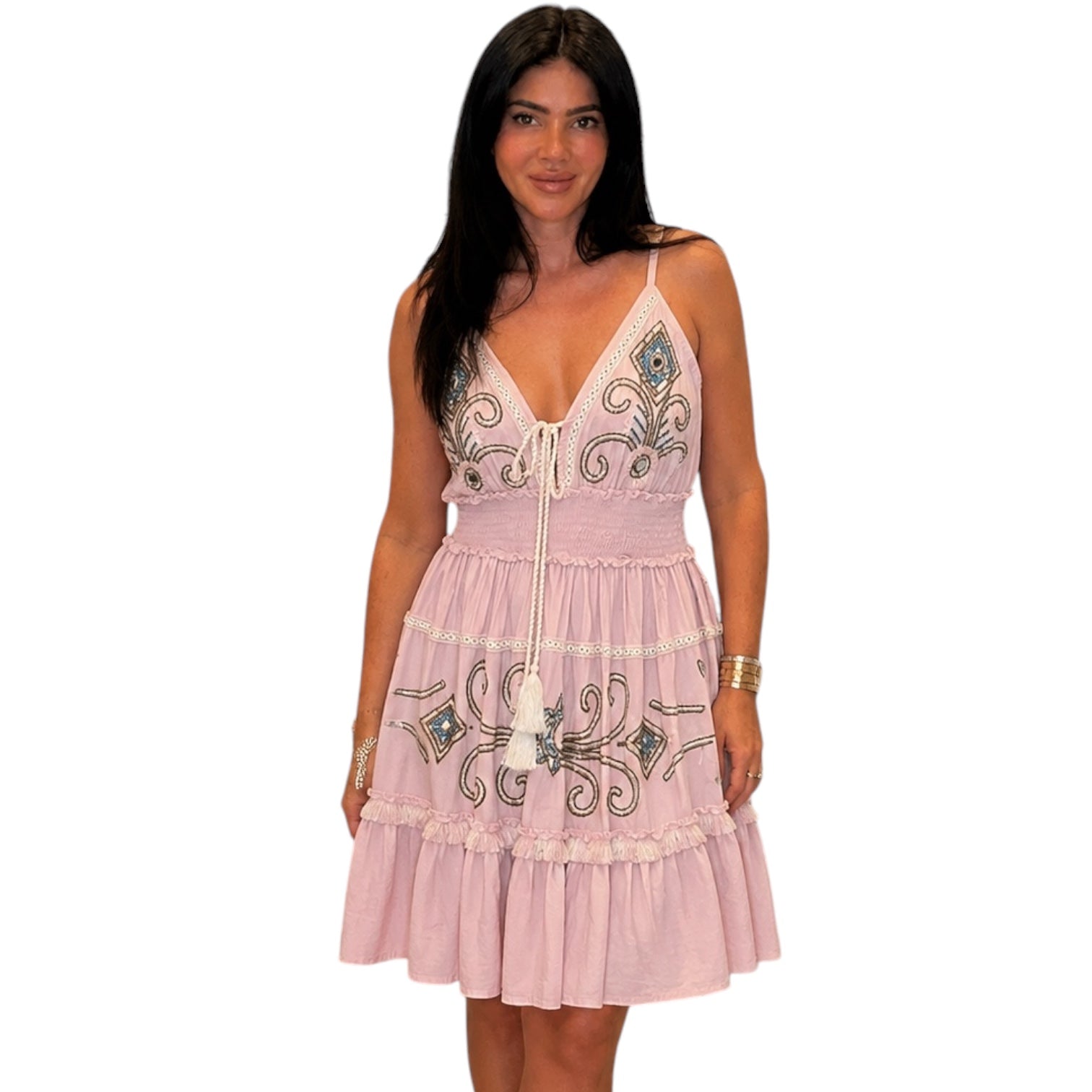 Woman wearing a pink dress with intricate patterns on a white background