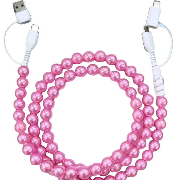 Pink beaded cable coiled on a light wooden surface with a laptop in the background.