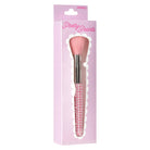 A pink makeup brush with a pearl-embellished handle and silver ferrule, presented in its light pink Pretty Pearls retail packaging against a white background.