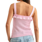 Pink knitted tank top with ruffled trim worn by a person on a white background