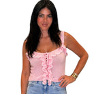 Woman wearing a pink ruffled top and blue jeans on a white background