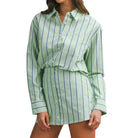 Green and white striped skirt set worn by a person on a white background