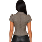 A woman viewed from the back wearing a fitted short-sleeve blazer with a brown and beige gingham pattern and puffed shoulders, paired with black leather pants, against a plain white background.