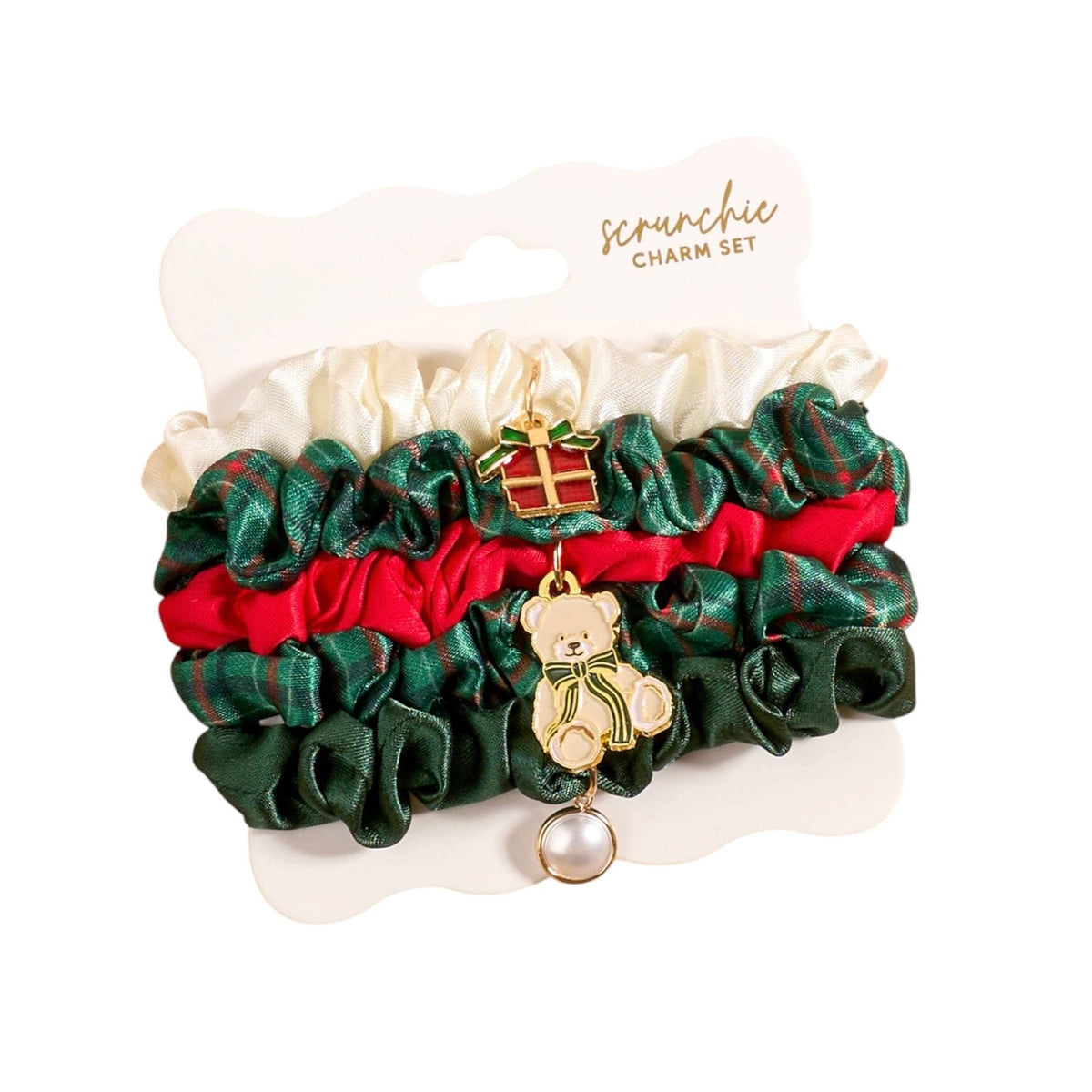 Scrunchie charm set featuring three ruffled scrunchies in green plaid, red, and cream satin, decorated with a gold teddy bear charm wearing a green bow and a small gold bell.