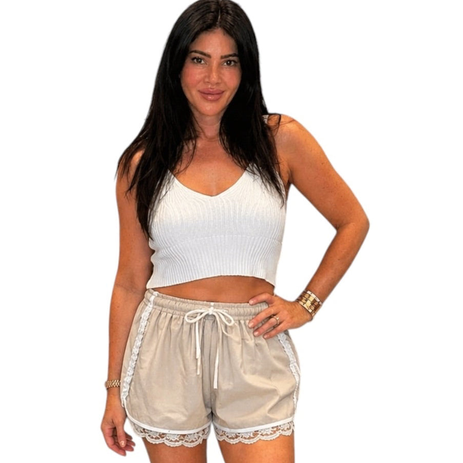 woman wearing beige shorts with white lace trim