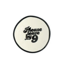 Round white trinket dish with black text 'Please leave by 9' on a white background