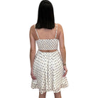 Woman wearing a polka dot dress on a white background