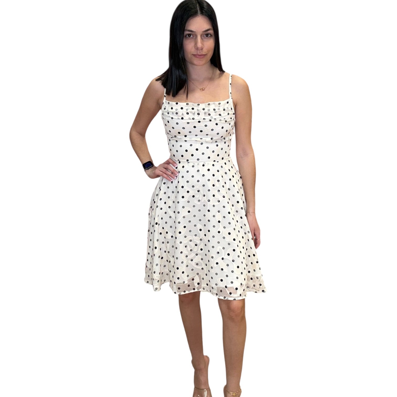 Woman wearing a white dress with black polka dots on a white background