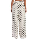 Polka dot pants worn by a person on a white background