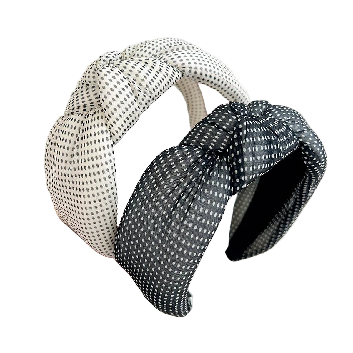 Two polka dot headbands, one beige and one black, held by a hand on a white background.